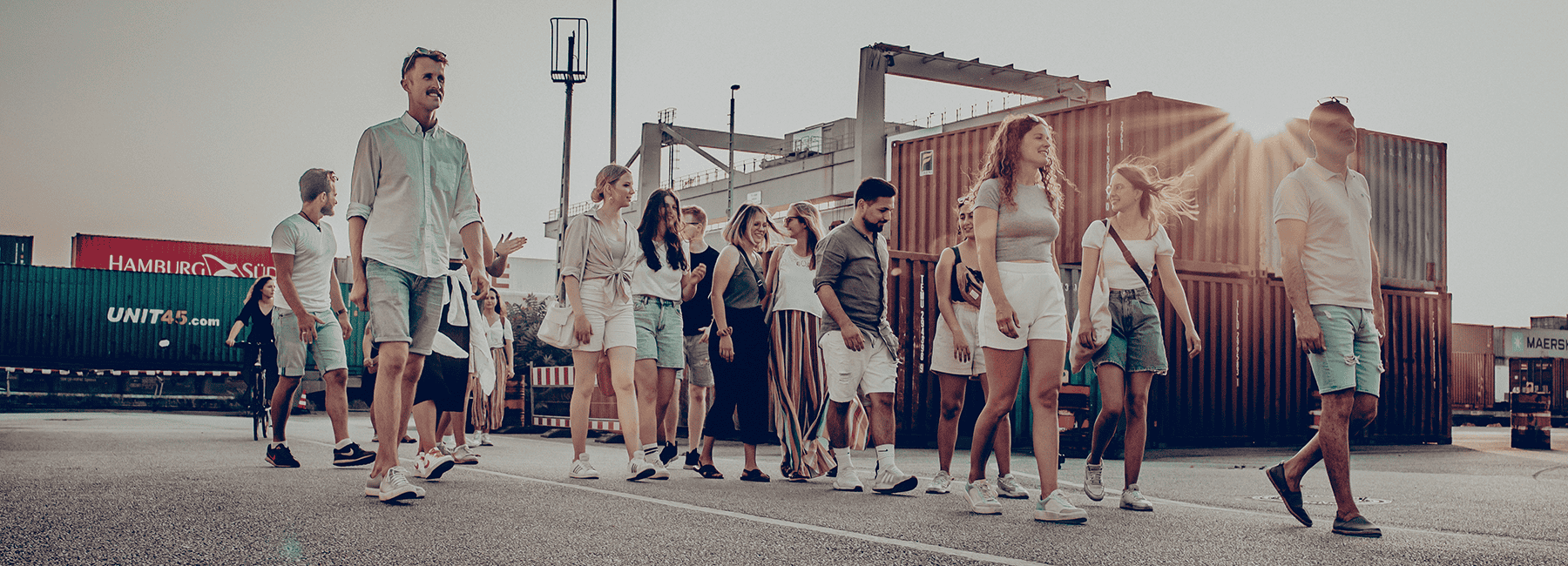 1. Gruppe junger Menschen beim Spaziergang am Hafen, Sonne, Urban, Gemeinschaft, Freizeit, Lifestyle, Mannheim, moderne Gesellschaft, Freunde, outdoor, positiv, Zusammenhalt, junge Community.