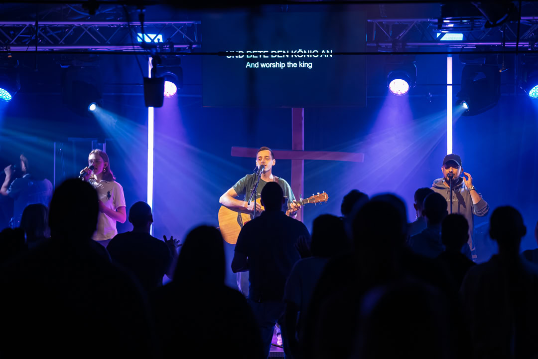 Live-Gottesdienst mit Musik und Anbetung bei ICF Basel-Land, featuring Musiker auf der Bühne vor einer Gemeinde in einem modernen Kirchenraum.