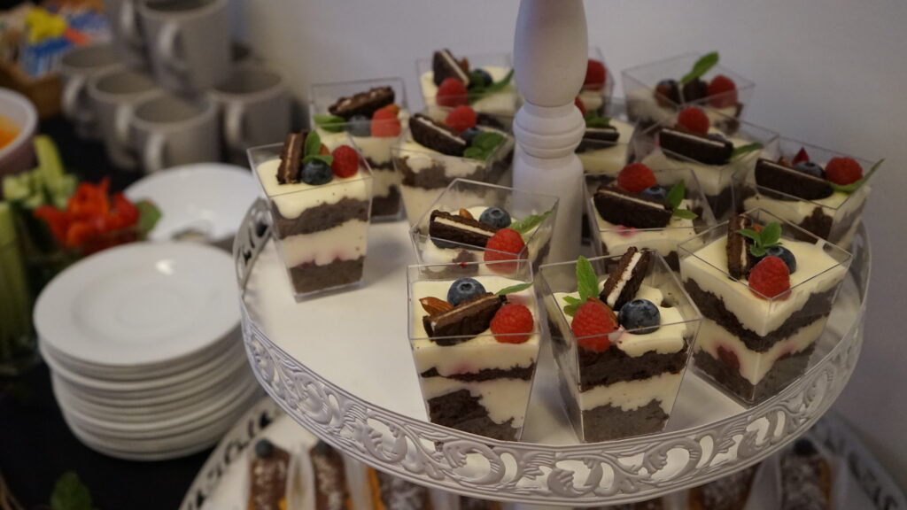 Schichtdesserts mit Beeren und Schokolade, serviert auf einer Glasplatte.