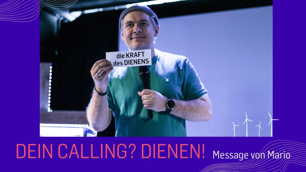 Mann hält ein Schild mit der Aufschrift "die KRAFT des DIENENS".