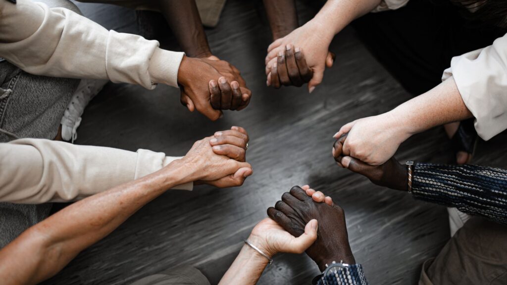 Several hands touching in the middle.
