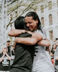 Two women embrace emotionally.