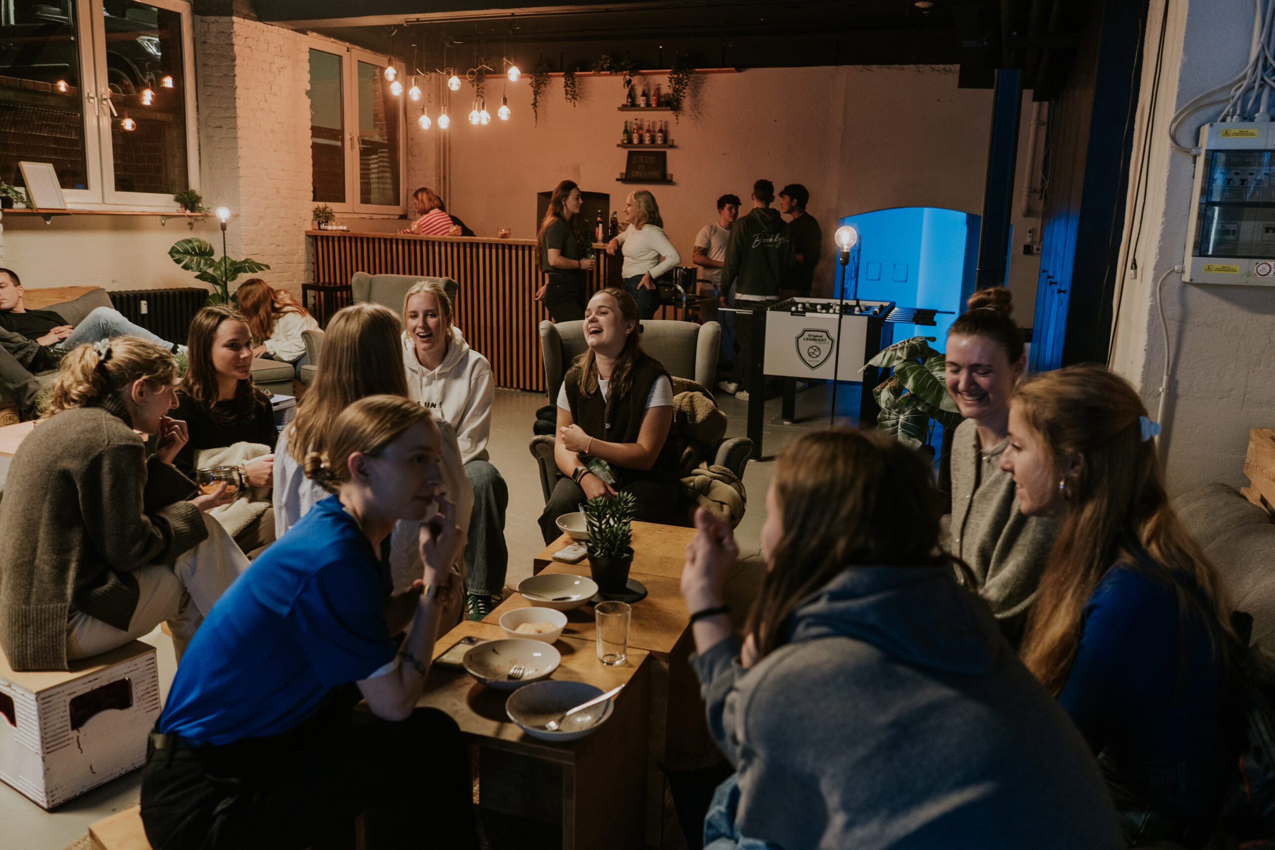 Freunde und Gemeindemitglieder bei einem Gemeinschaftsabend im ICF Berlin, die sich in einem gemütlichen Raum versammeln, lachen und Gespräche führen.