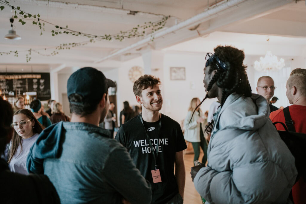 Menschen bei einer Gemeinschaftsveranstaltung im ICF Berlin, freundliche Interaktion, offene Atmosphäre, junge Erwachsene, Gemeinschaft, christliche Kirche, Event, Zusammenkunft.