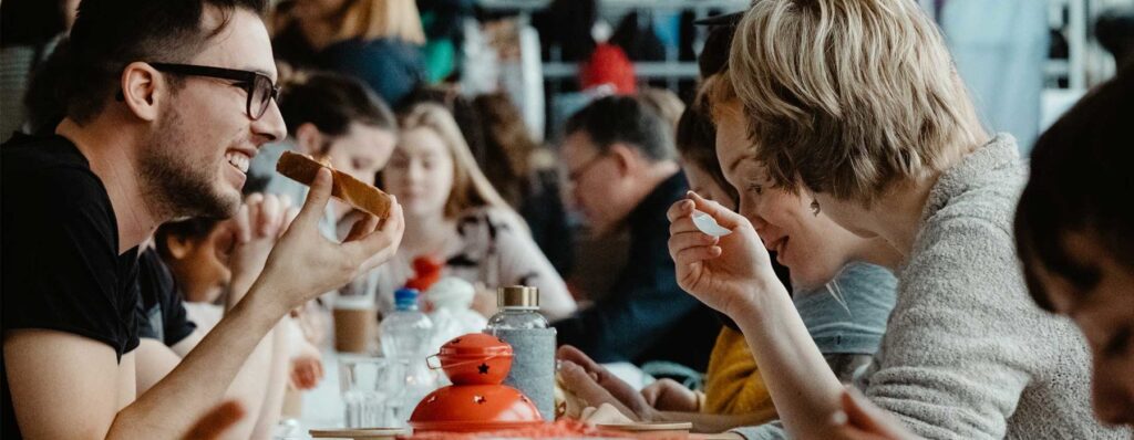 Menschen, die bei ICF Bern Gemeinschaft beim Essen erleben, genießen einen angenehmen Austausch und inspirierende Gespräche in einer offenen, herzlichen Atmosphäre.