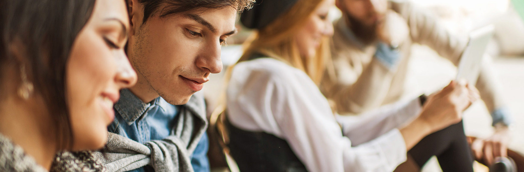 Menschen sitzen zusammen, lachen und nutzen digitale Geräte bei ICF Bern, einer modernen Kirche in der Schweiz, die Gemeinschaft, Inspiration und Glauben fördert.