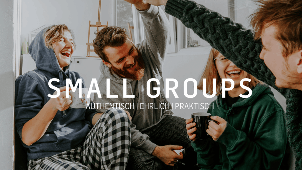 Vier Menschen sitzen in einem Raum, lachen und trinken Kaffee.