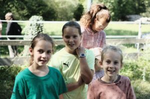 Kinder beim Spielen und Engagieren im Freien, umgeben von Natur.