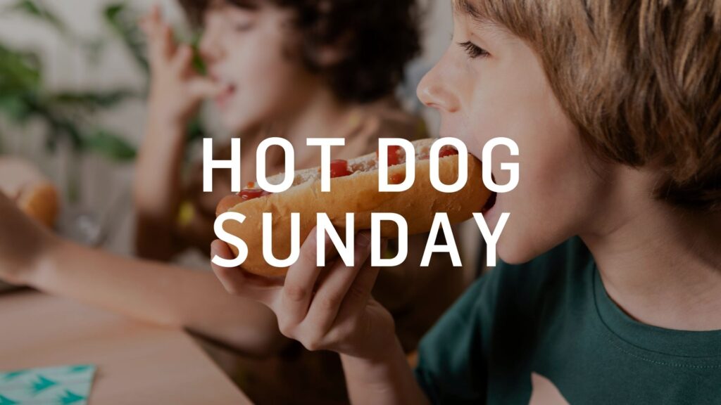 Junge Menschen genießen ein Hot Dog beim beliebten Gemeinschafts-Event "Hot Dog Sunday" bei ICF Thun, das Gemeinschaft, Spaß und gutes Essen verbindet.