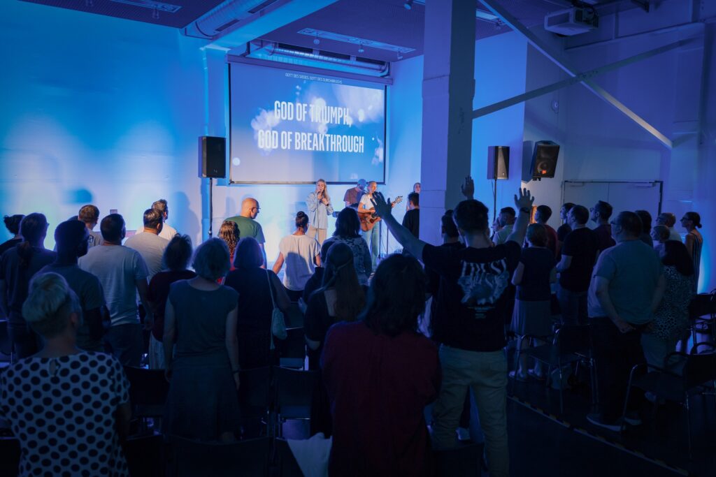 Gemeinschaftlicher Gottesdienst bei ICF Hamburg mit Predigt und Lobpreis in moderner Kirche.