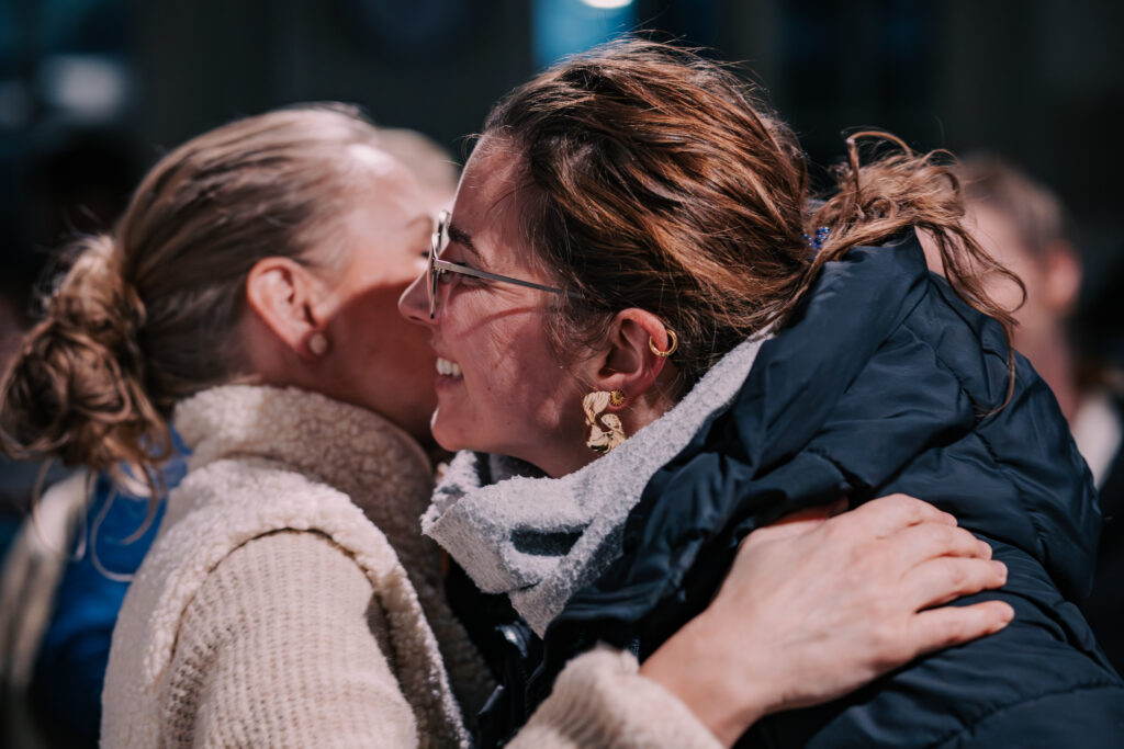 Zwei Frauen umarmen sich herzlich bei einer Veranstaltung von ICF Hamburg, die Gemeinschaft und Zusammenhalt in der christlichen Gemeinde betont.