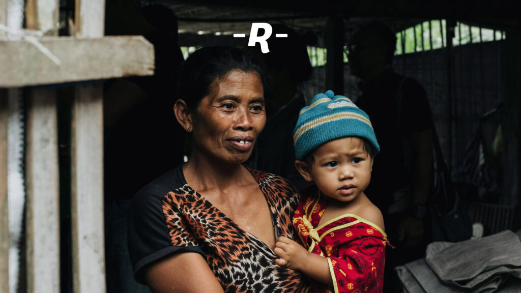 Vielfalt von Menschen bei einem Gemeinschaftsessen in modernem, hellem Raum mit dekorativen Glühbirnen und Holzpaneelen; Ausdruck von Zusammenhalt und sozialer Interaktion in einer informellen Umgebung.