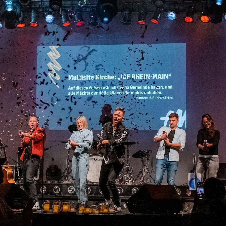 Menschen beim Gottesdienst in der ICF Rhein-Main Multisite Kirche, inspirierende Predigt, moderne Bühne, Gemeinschaft, christliche Veranstaltung, Glaube, Kirche, Musik, Anbetung, Gemeinschaftsgefühl.