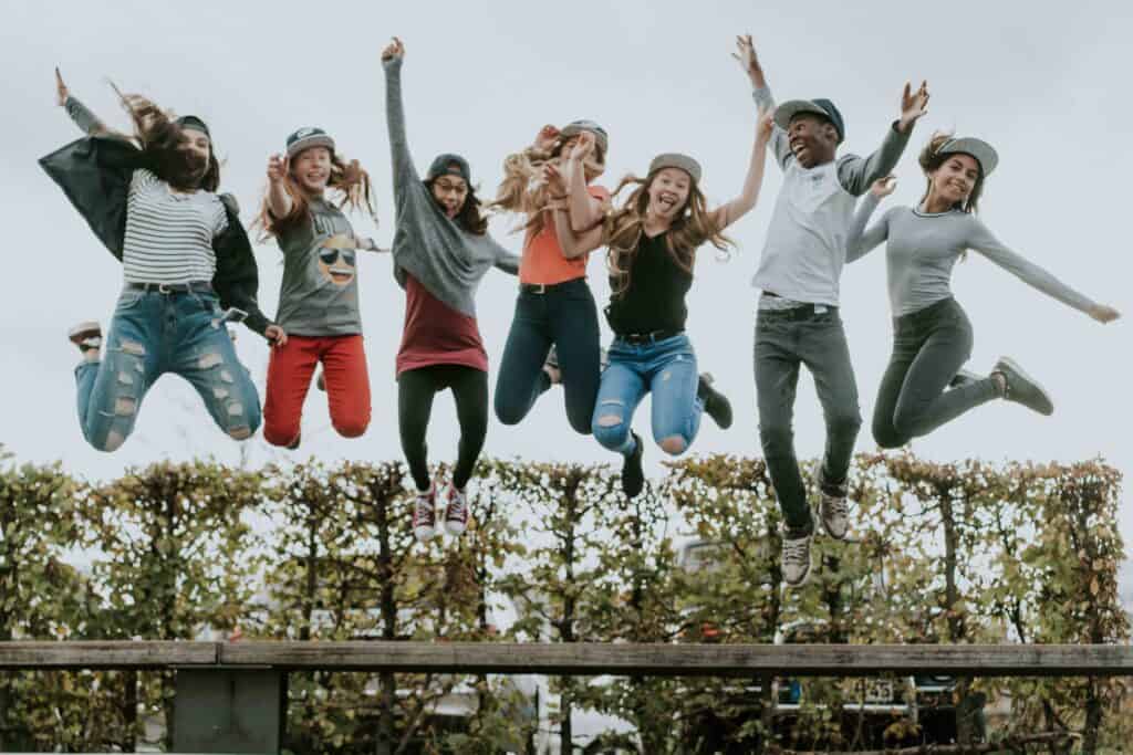 Young people jumping, laughing and happy, at an ICF Munich event, life-affirming atmosphere and community.