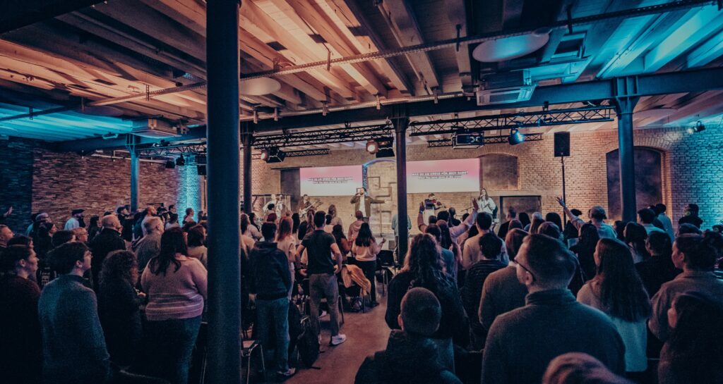 Alt-Text: Lebendige Gemeindeveranstaltung bei ICF Mannheim mit Worship, Predigt und Gemeinschaft in einem modernen, offenen Kirchenraum.